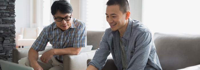 Father and son looking at laptop for best personal checking
