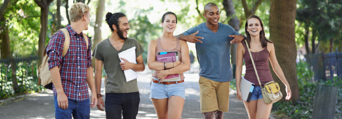 Ethnically diverse group of smiling students walking on college campus Ethnically diverse group of smiling students walking on college campus