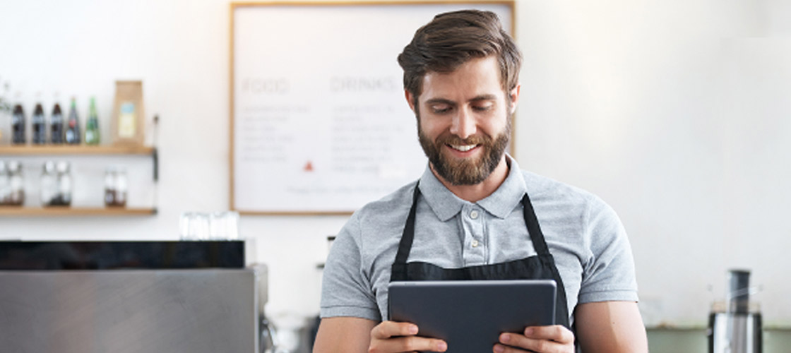 Small business owner on his tablet for online banking and account balance 