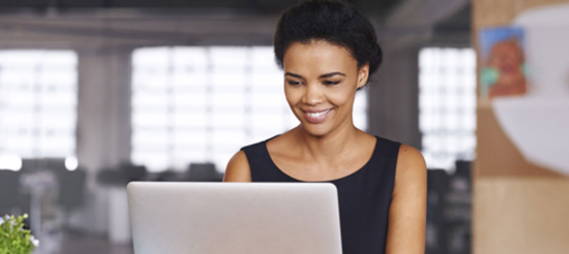 Smiling female on her laptop for electronic deposit secure safe