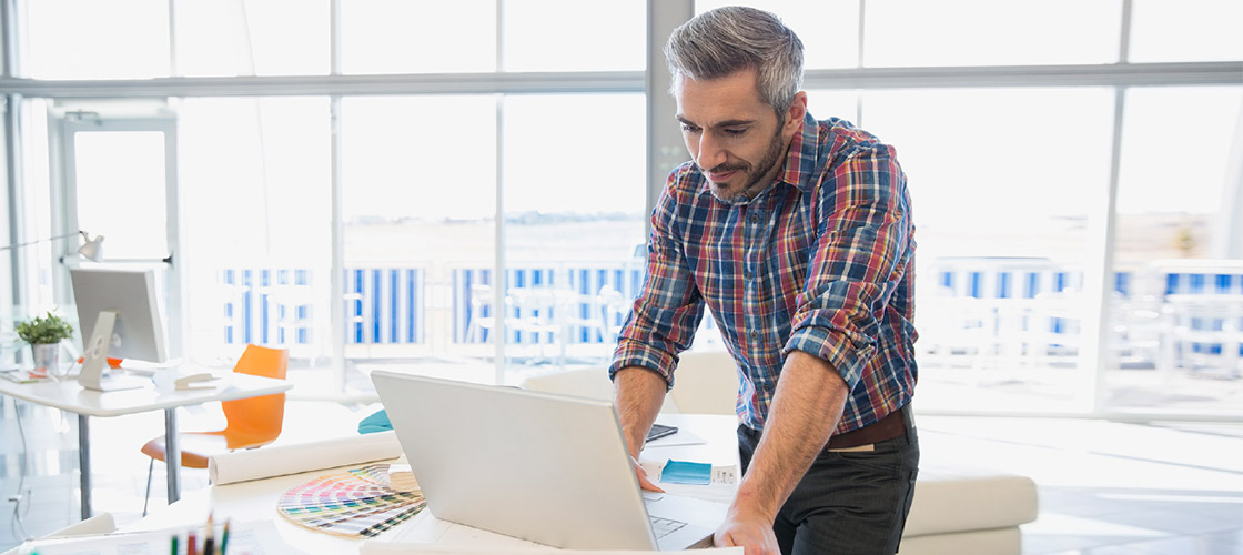 Business owner using his laptop for cash management services 
