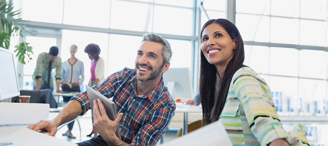 Male and female small business team look up happily