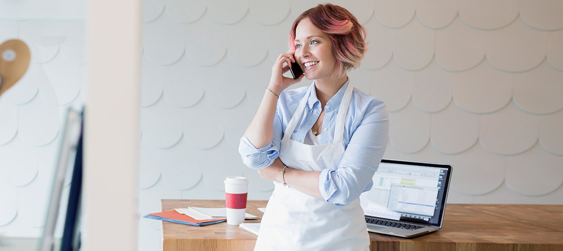 Female small business owner on her phone for SBA financial services Female small business owner on her phone for SBA financial services