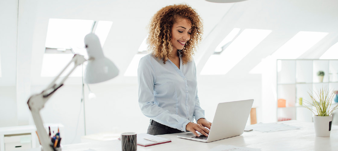 Smiling small business owner looking at her laptop to make online payment 