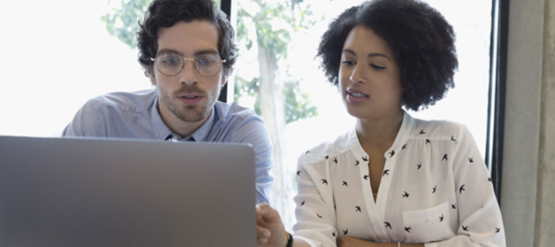 Business owners looking at computer for wire transfer services 