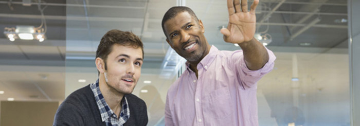 Small business owner and employee looking up optimistically Small business owner and employee looking up optimistically