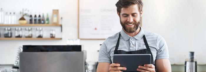 Small business owner on his tablet for online banking and account balance Small business owner on his tablet for online banking and account balance