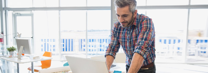 Business owner using his laptop for cash management services Business owner using his laptop for cash management services