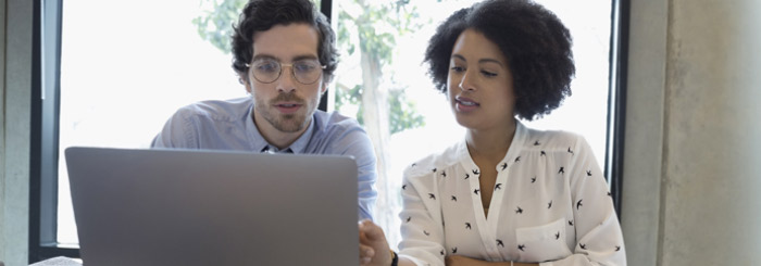 Business owners looking at computer for wire transfer services 