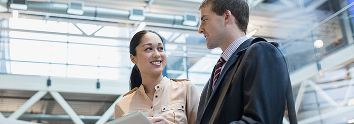 Smiling coworkers looking at each other on foreign business trip