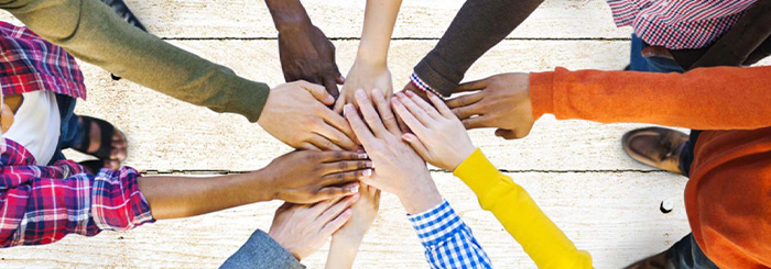 Multiple hands stacked on top of each other showing teamwork 