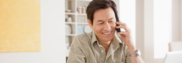 Smiling optimistic man on the phone with a loan servicing specialist Smiling optimistic man on the phone with a loan servicing specialist