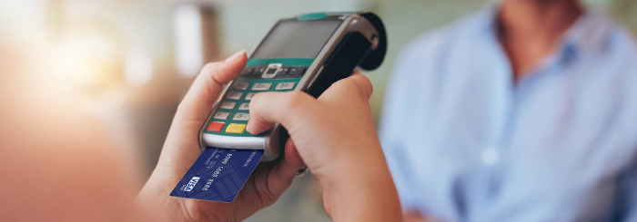 Hand holding a chip card reader with inserted debit credit card Hand holding a chip card reader with inserted debit credit card