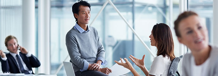 Risk management team discussing foreign exchange services Risk management team discussing foreign exchange services