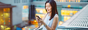 Smiling female on her mobile phone for personal international  banking