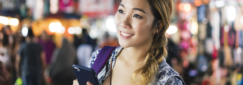 Girl holding a smartphone in a crowd