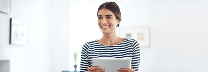 Smiling business woman holding a tablet in office Smiling business woman holding a tablet in office